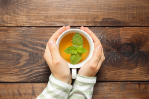 Female hands holding a cupa of mint tea